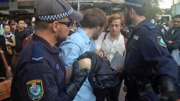 A student protester is taken away by police after a scuffle in the Sydney CBD.