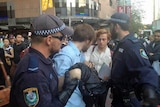 A student protester is taken away by police after a scuffle in the Sydney CBD.