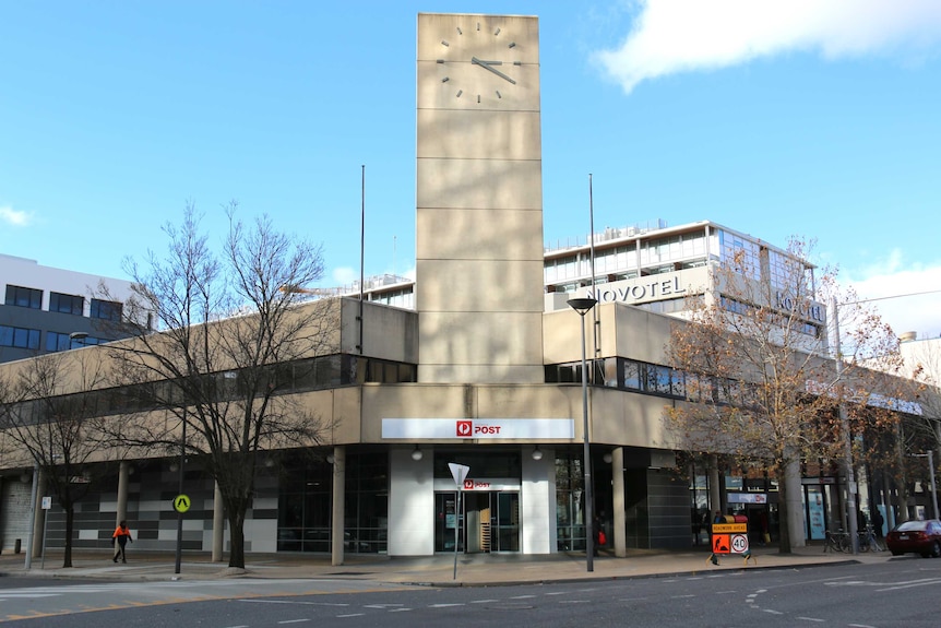 A post office with a clock on top.