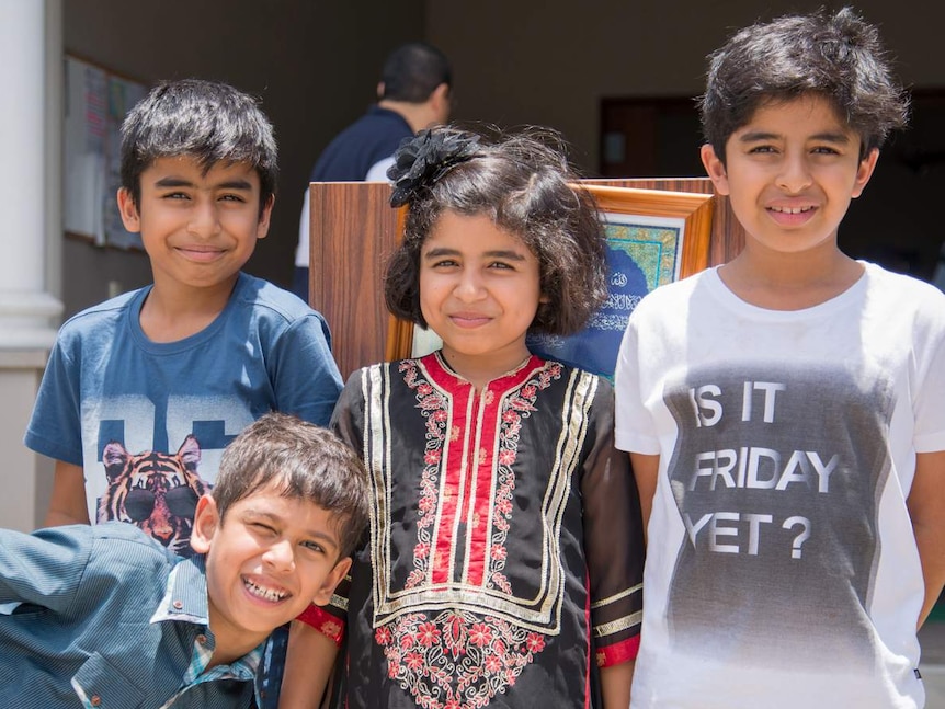 Four children from Cairns' Islamic community pose for a photograph during the National Mosque Open Day event.
