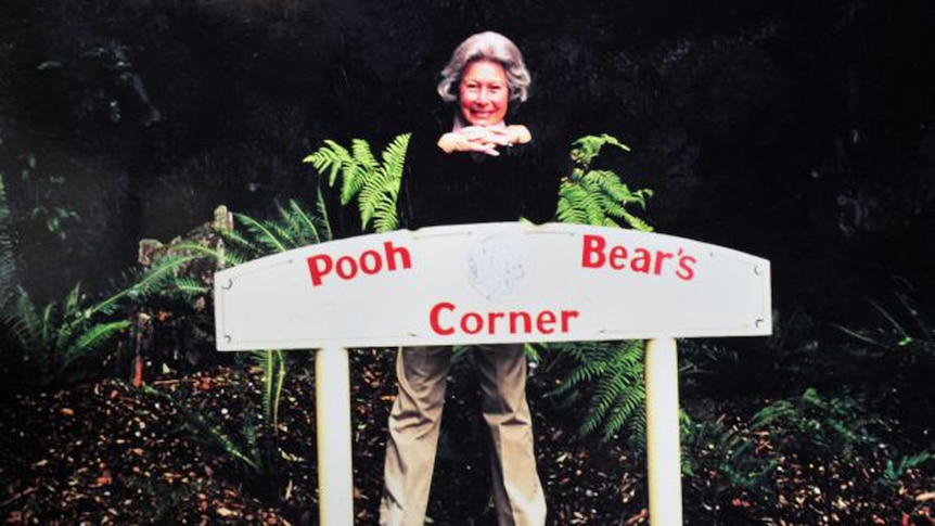 Lady pictured in an older photo with a sign saying 'Pooh Bear's Corner'