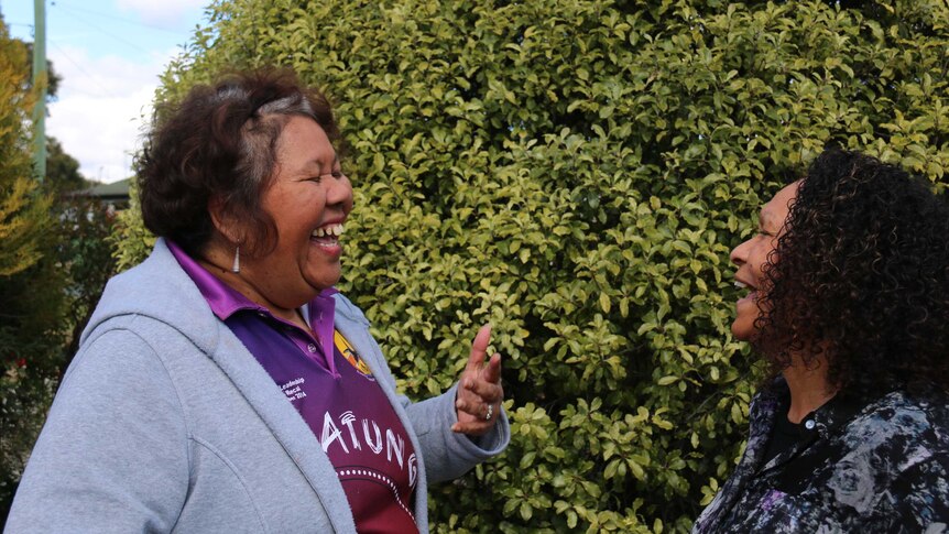 Two women laugh.