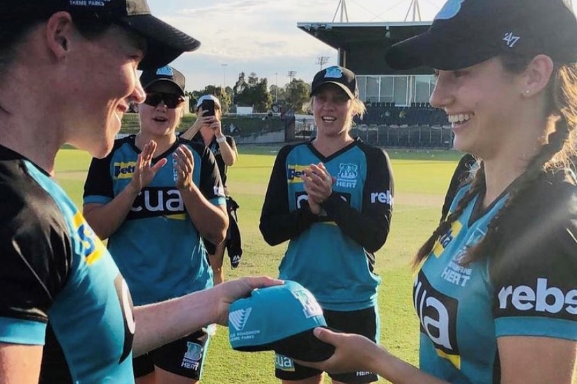 Cricket player Charli Knott receives her cap on debut for the Brisbane Heat.