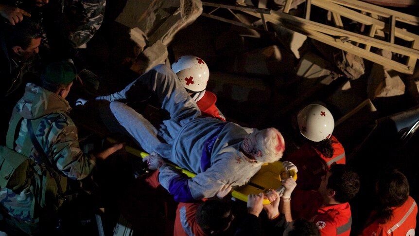 A survivor is carried form the ruins of a collapsed building in the Lebanese capital Beirut