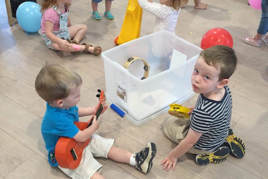 Children play with a variety of musical instruments.