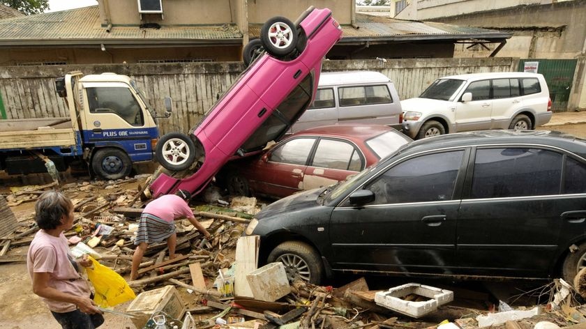 Two people search for usable materials as floodwaters recede in Marikina City