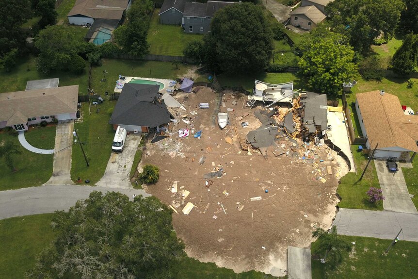 Debris is strewn about after a sinkhole damaged two homes in Land O' Lakes