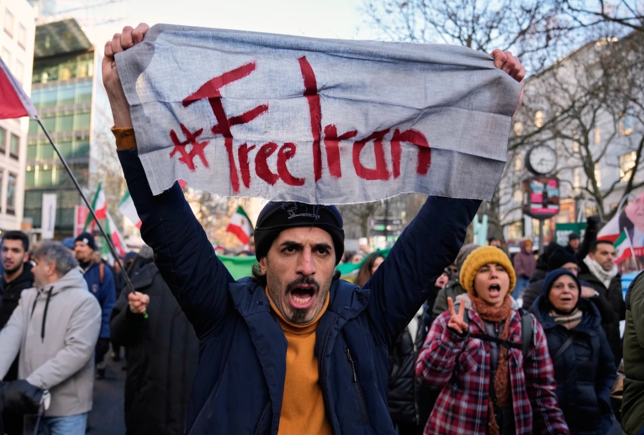 Um homem segura uma placa durante um protesto no Irã.