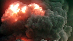 Iraqi villagers view burning oil pipeline in northern Iraq near Kirkuk.