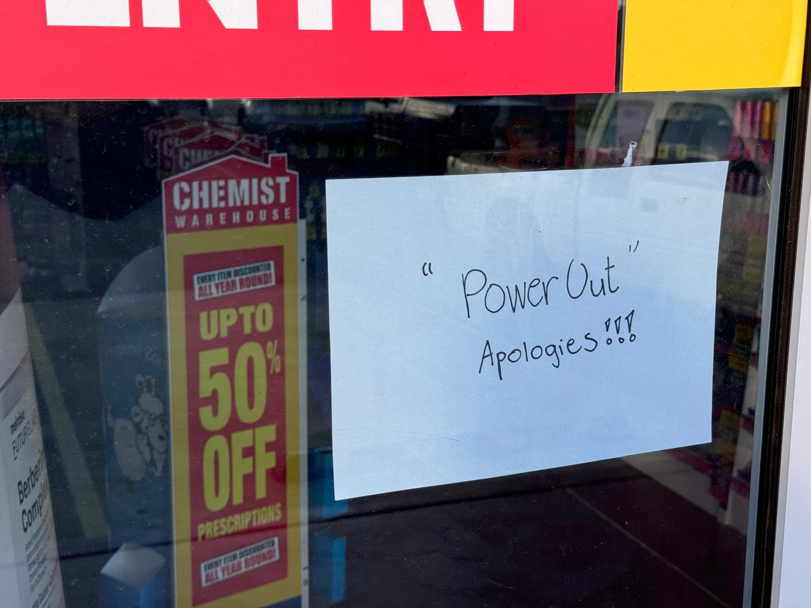 A sign on a shop window saying &quot;Power Out, Apologies&quot;