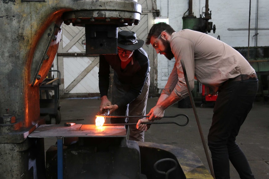 A man working with another man in the studio