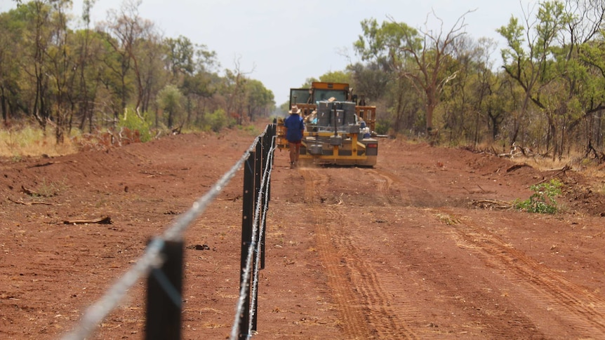 A tractor makes its way down a dirt road in northern Australia.