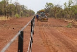 A tractor makes its way down a dirt road in northern Australia.