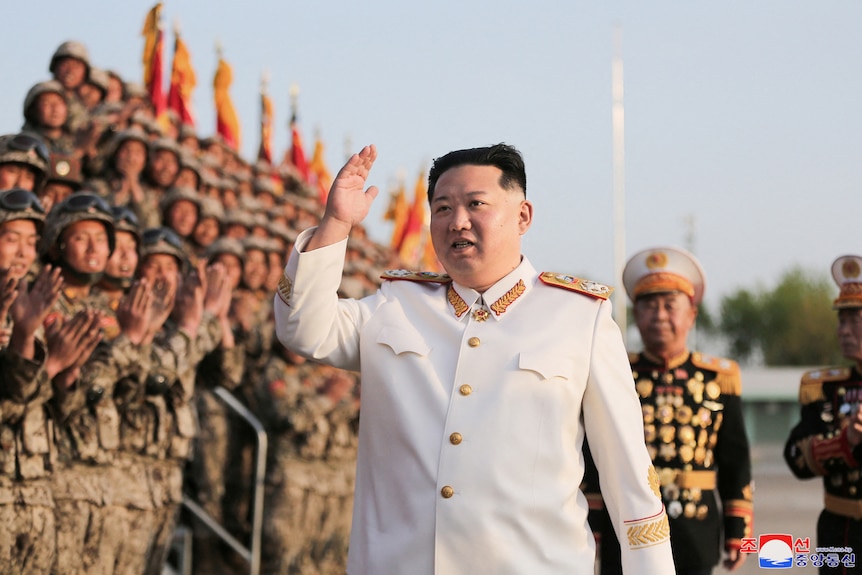 Северокорейский лидер Ким Чен Ын приветствует солдат во время военного парада