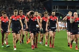 Nathan Jones (R) leads Melbourne off Kardinia Park after a loss to Geelong on July 21, 2018.
