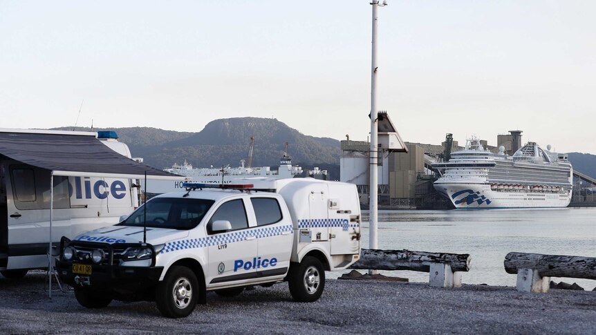 A police van is seen in front of the Ruby Princess cruise ship.