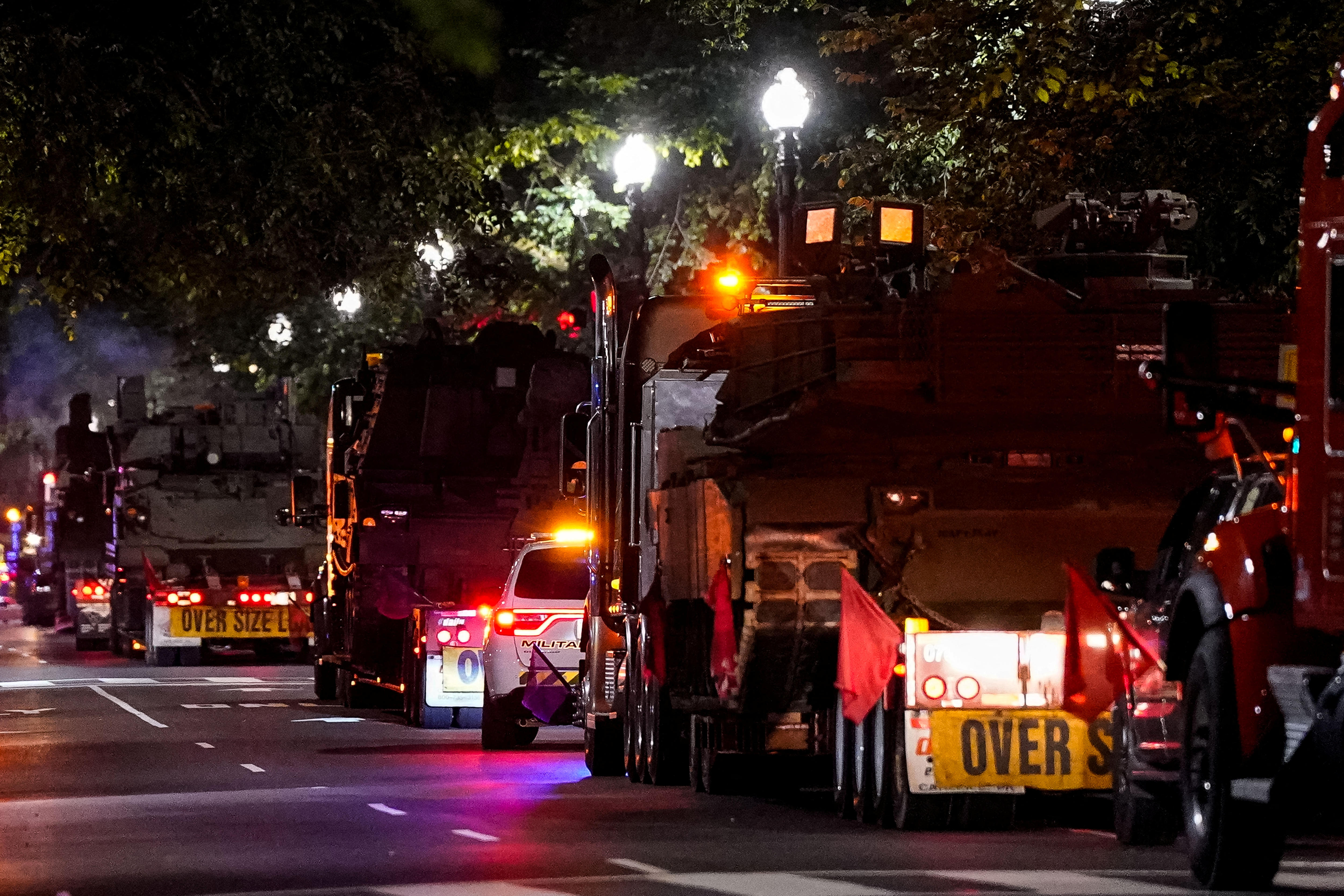 convey of army trucks drives through Washington at night.