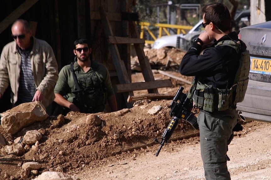 Israeli soldier guarding newly built wall