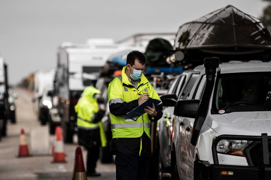 Un responsable de la quarantaine parle à un automobiliste à la frontière WA/SA. 