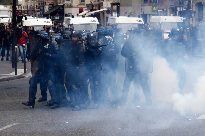 French riot police are surrounded by tear gas.