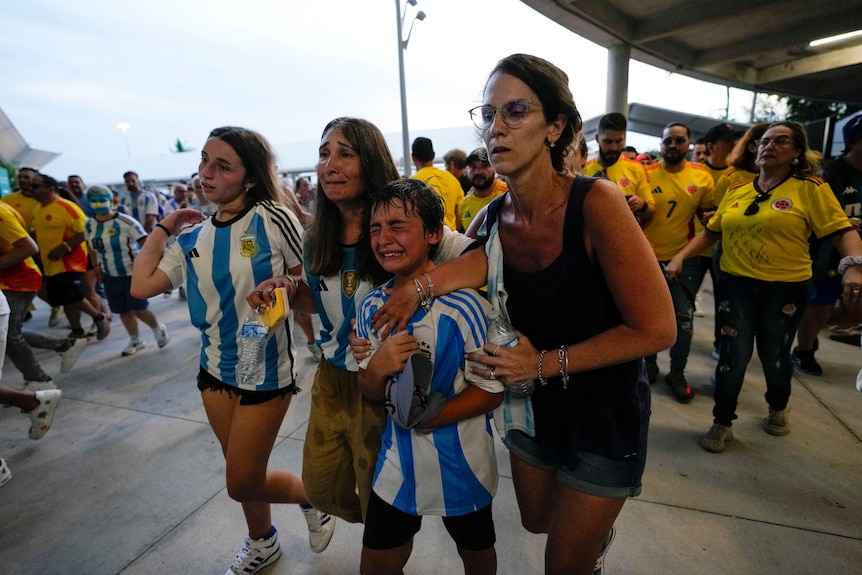 Children and adults crying at they attempt to enter a stadium