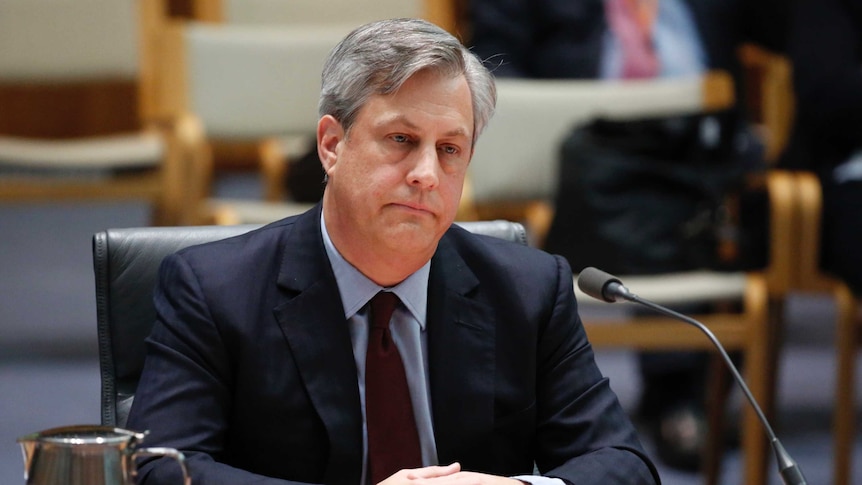 Westpac CEO listens to questions with an unhappy look on his face during the banking inquiry.