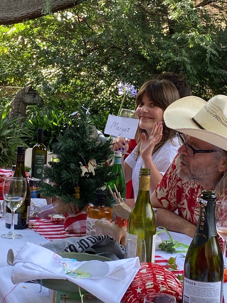 A girl waving to the camera at a Christmas lunch. 