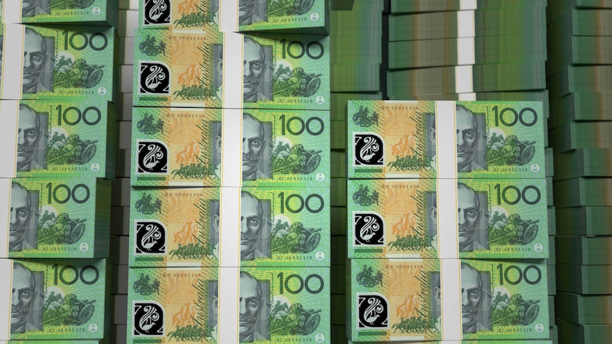 Wads of Australian $100 notes piled on top of each other.