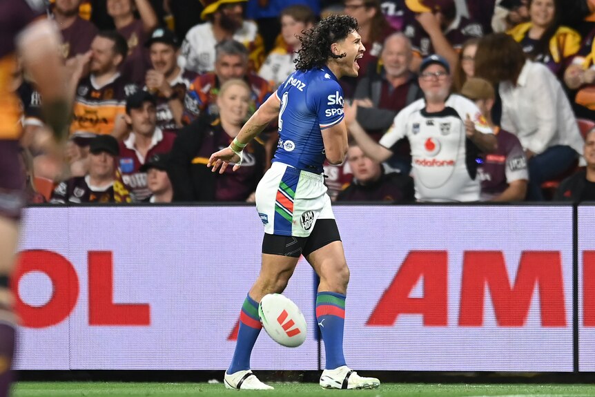 An NRL palyer, screaming with excitement, in front of a pack grandstand of fans