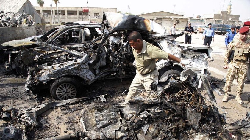 A security guard sifts through wreckage of a car bomb attack in Basra, in Iraq on August 25, 2010.