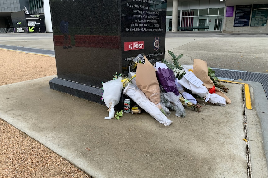 A tin of beer and a meat pie are seen amid floral tributes for Shane Warne.