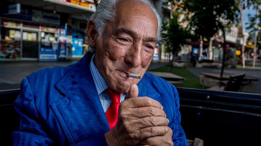 Footscray resident John Halilovich lights a cigarette.