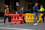 People walk across the street in Sydney CBD
