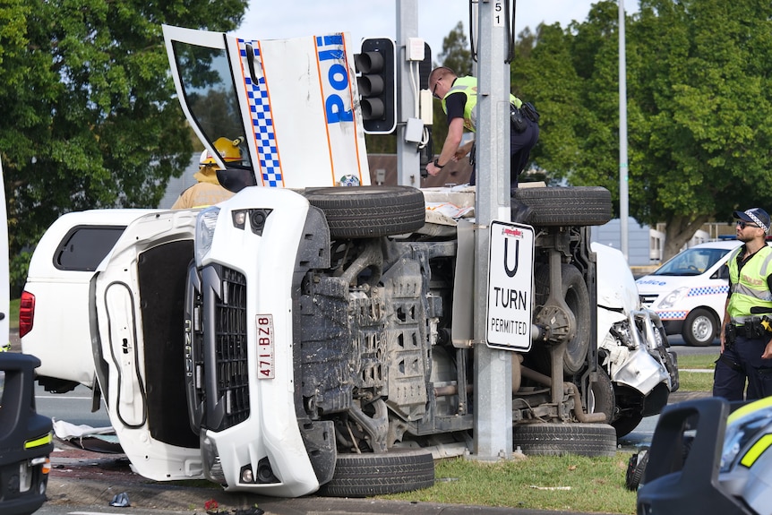 a police car on it's side next to a pole