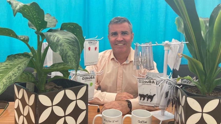 Oakey State High School principal Danny Keenan sitting in front of some of the products for sale by Oshoba