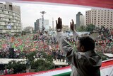 Iran's President Mahmoud Ahmadinejad waves to a sea of thousands of flag-waving supporters