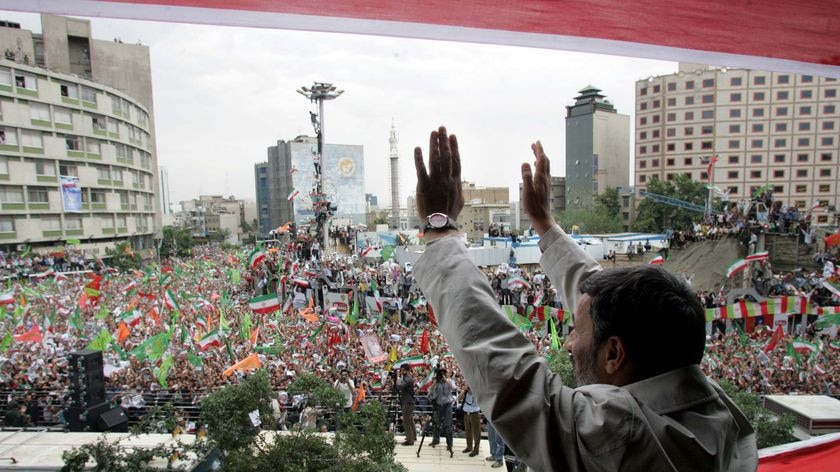 Iran's President Mahmoud Ahmadinejad waves to a sea of thousands of flag-waving supporters