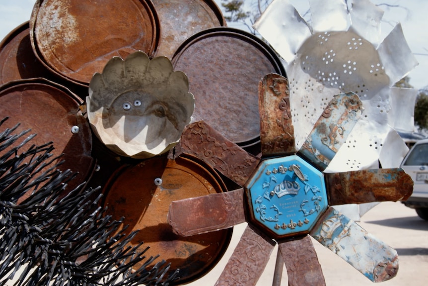 Metal artwork made out of colanders to look like a floral arrangement