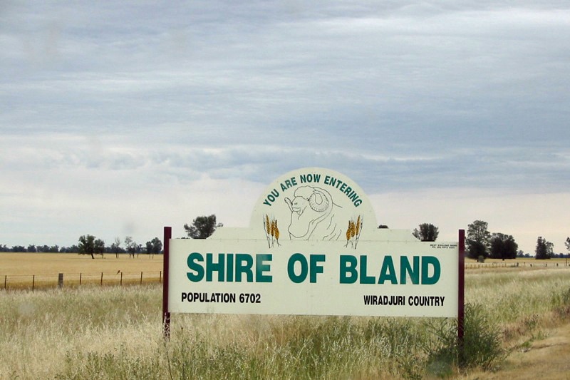 A roadside sign says 'You are now entering Shire of Bland'.
