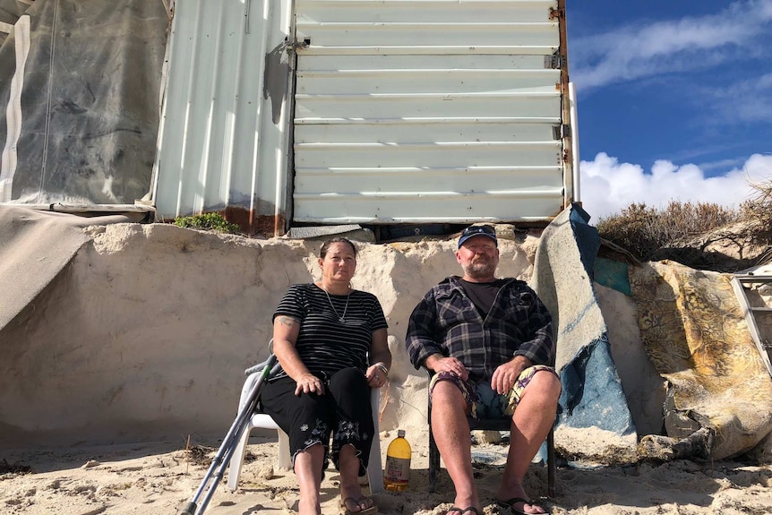 Kerry and Rob Howell sit in front of their crumbling shack.