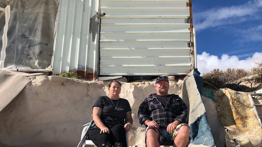 Kerry and Rob Howell sit in front of their crumbling shack.