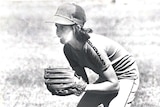 Girl wearing softball glove and a cap. 