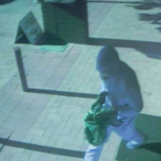 CCTV still of a man robbing a post office.