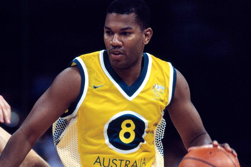 Australian basketballer Ricky Grace moves down the court with the ball in hand.