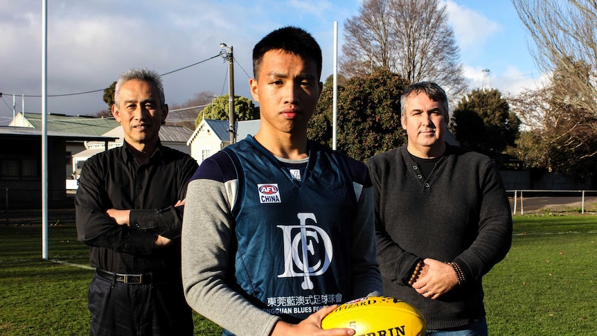 Dongguan Blues player Lu Tuwang with team liaison manager Darrell Egan and Ballarat's Charles Zhang.