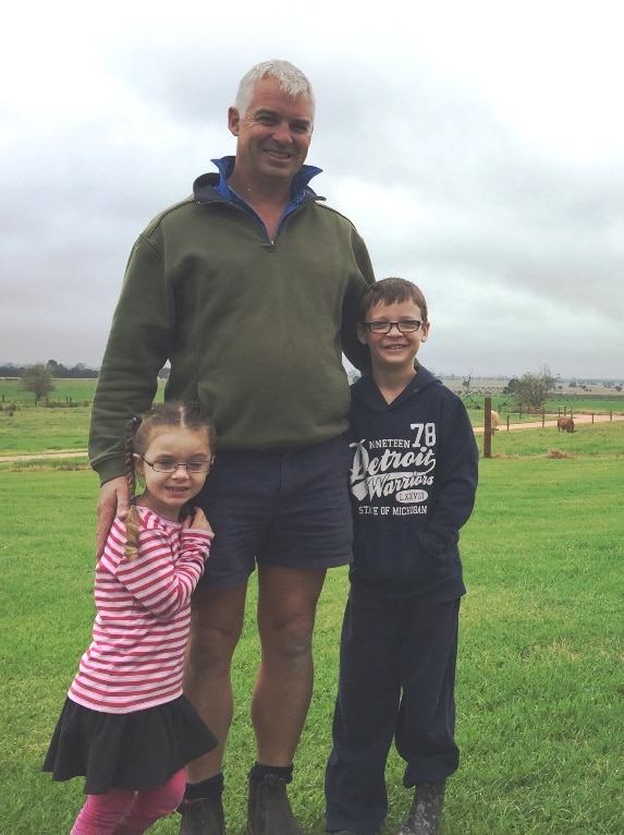 Audrey, Rohan and Harry Bingley standing in front of a green East Gippsland paddock.