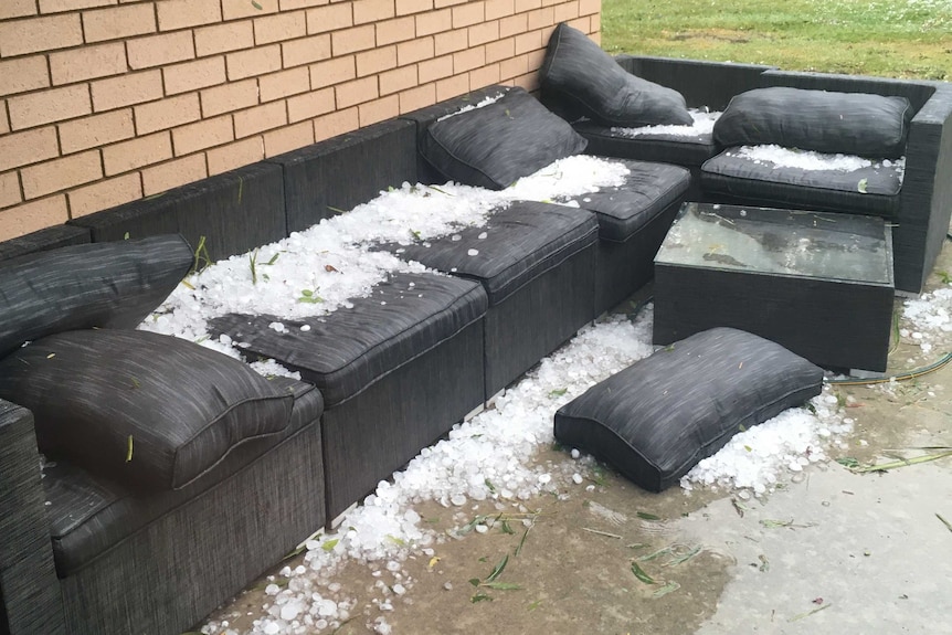 Large hailstones on top and around an outdoor couch.