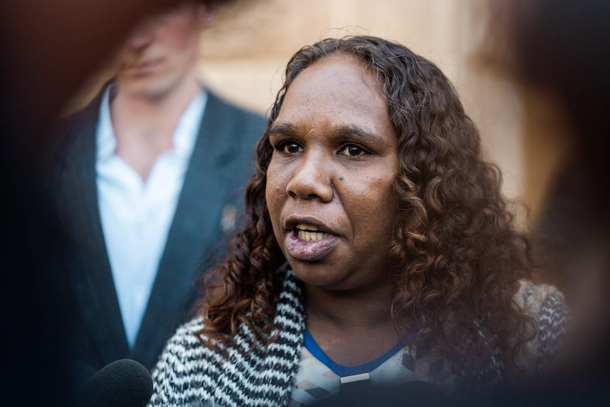 A close up of Bernadette speaking to the media.