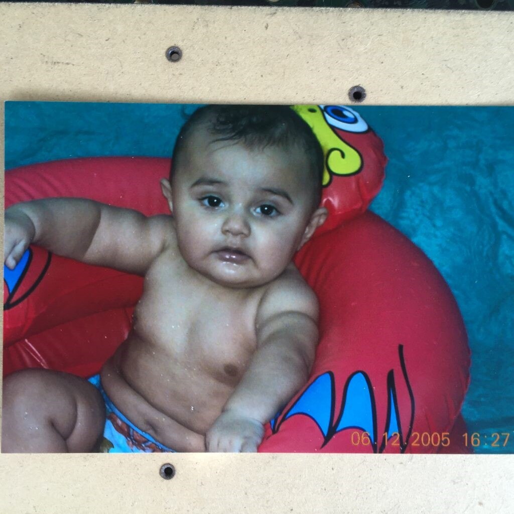Baby Baden Bond sits in a inflatable toy chair, date and location unknown.