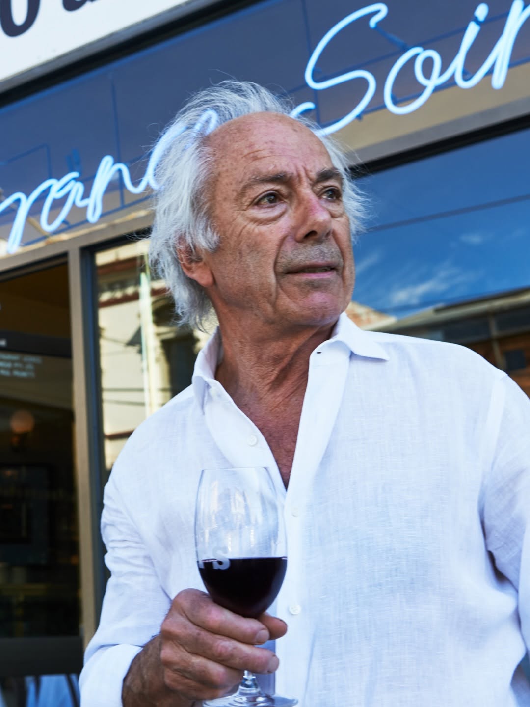 France-Soir owner Jean-Paul Prunetti enjoys a glass of wine outside France-Soir on its 40th anniversary